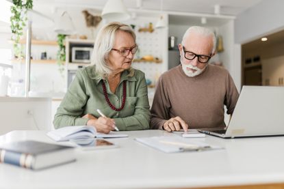Senior couple using laptop while planning their home budget