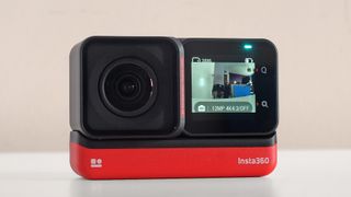 The Insta360 One RS action cam on a beige background