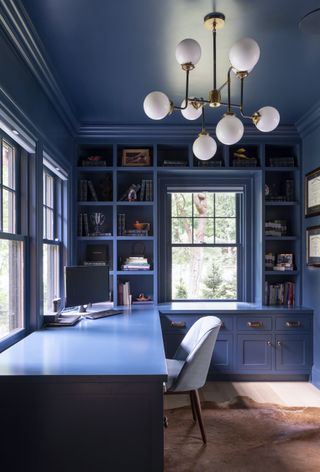 home office with navy blue gloss paint walls and cabinetry
