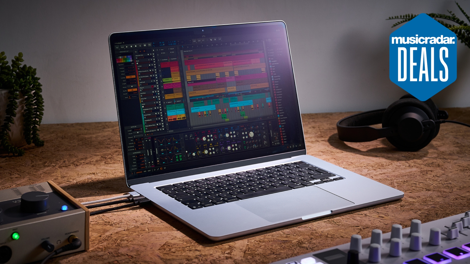 An Apple Macbook Air M4 on a desk with various bits of music making gear around it