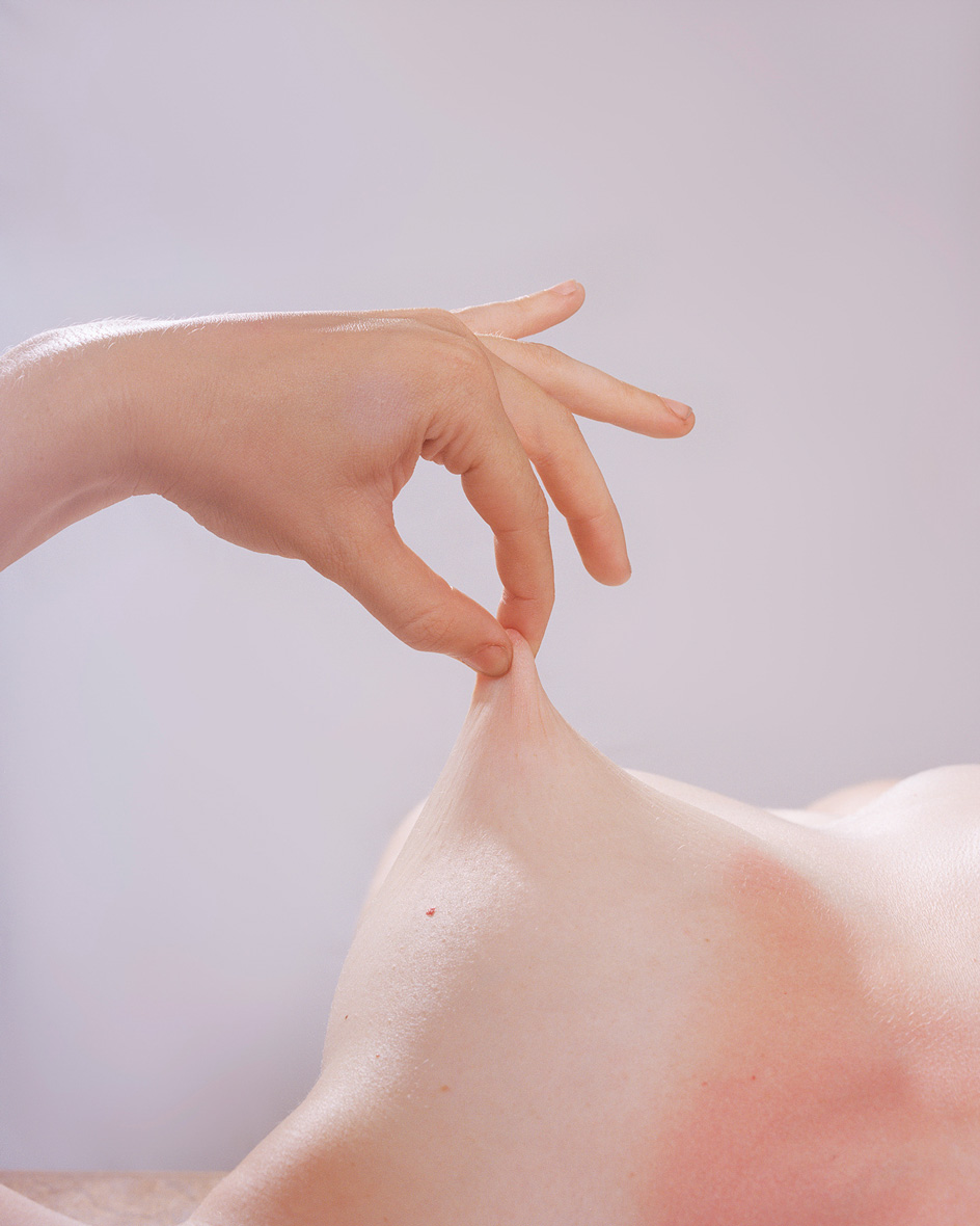 Close up photograph of nipple being pulled and pinched