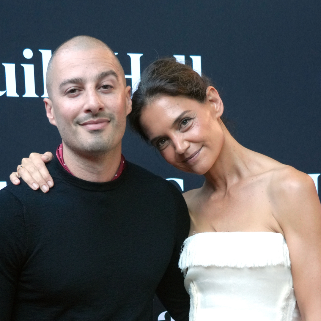 Katie Holmes wears a strapless white dress and carries a soft leather bag while posing with boyfriend Jason Bard Yarmosky at the 2026 Guild Hall Summer Gala on August 7, 2026