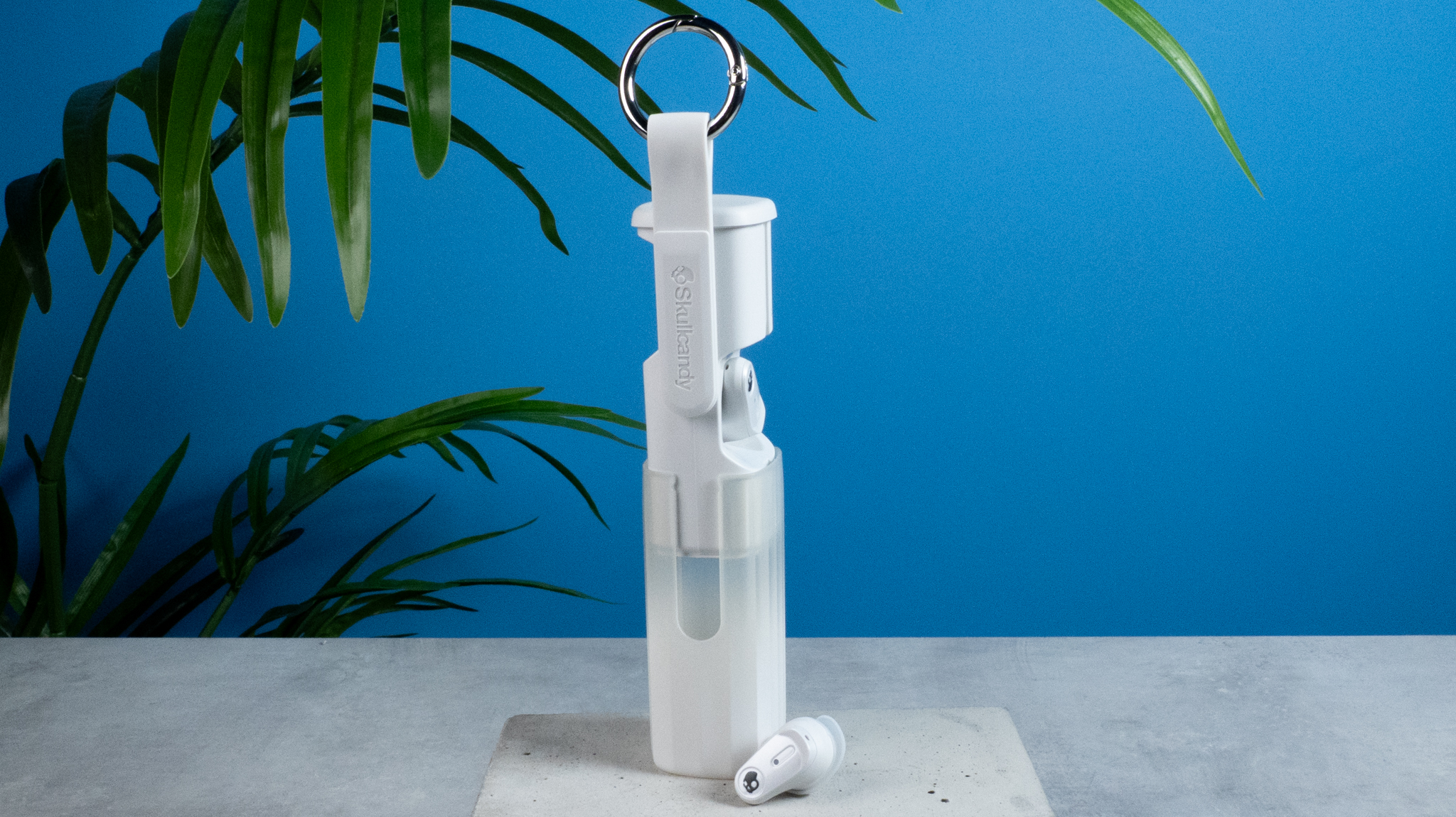 the skullcandy x bose method 360 anc earbuds in white, with a long charging case, a carabiner clip, and various silicone tip sizes