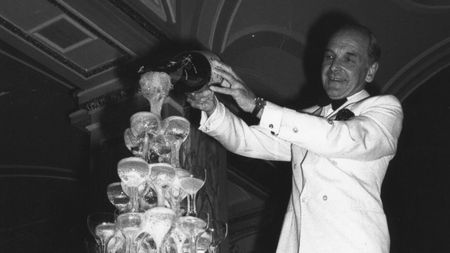 A waiter pours champagne into a tower of glasses to celebrate the opening of a new Casino at the Ritz Hotel, London, in 1978