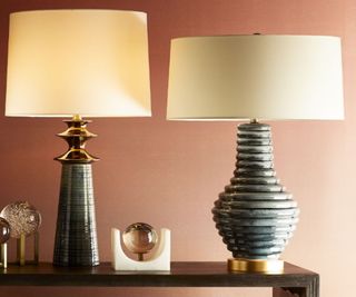 Two table lamps with ceramic bases on a sideboard