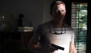 No Time To Die Daniel Craig in shadow, with his gun drawn