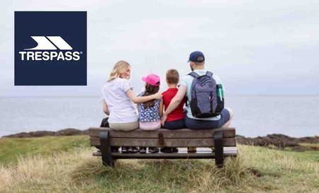 trespass logo placed over a family of four sitting on a bench over looking the sea