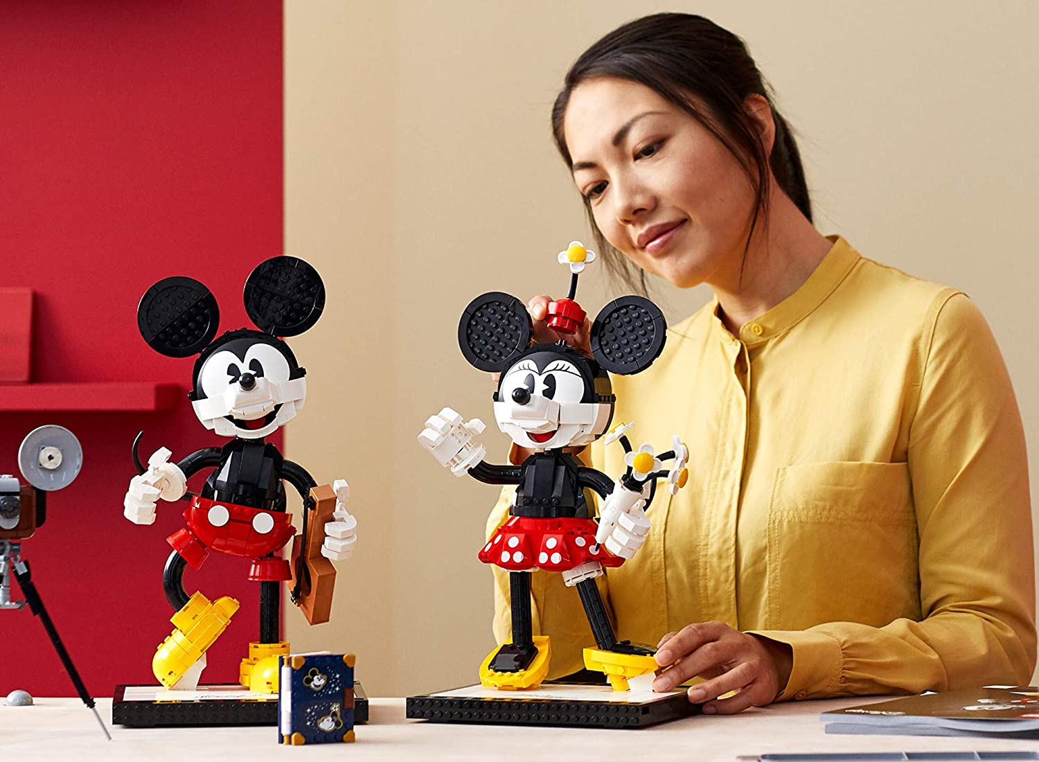 A photo of a woman admiring the LEGO Mickey Mouse and Minnie Mouse Buildable Characters set.