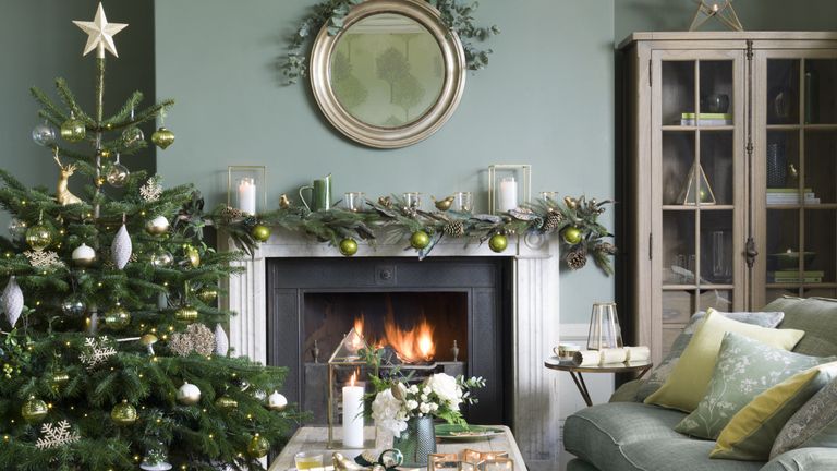 An example of Christmas decorating ideas in a green living room with an open fire