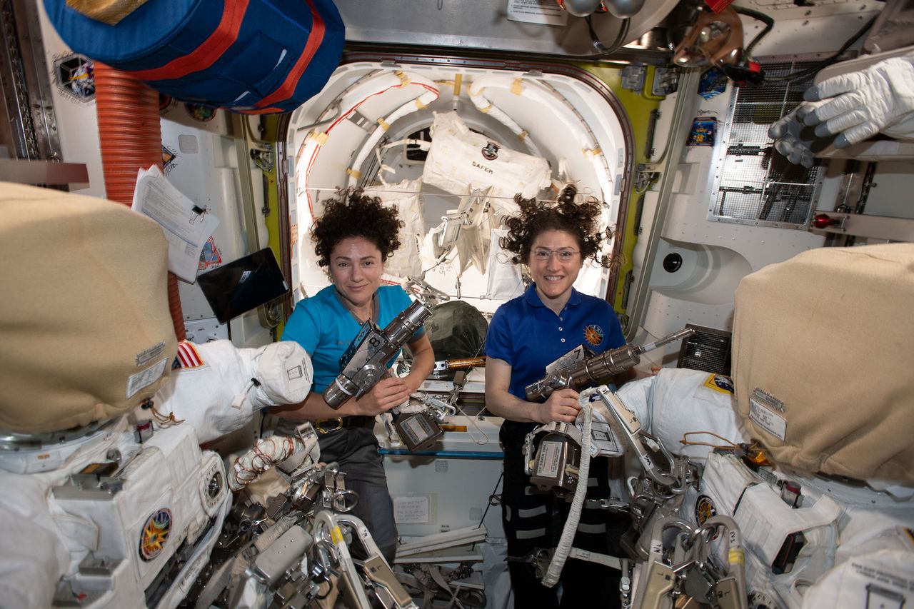 NASA astronauts Jessica Meir (center) and Christina Koch pose for a photo while preparing for an Oct. 18, 2019 spacewalk.