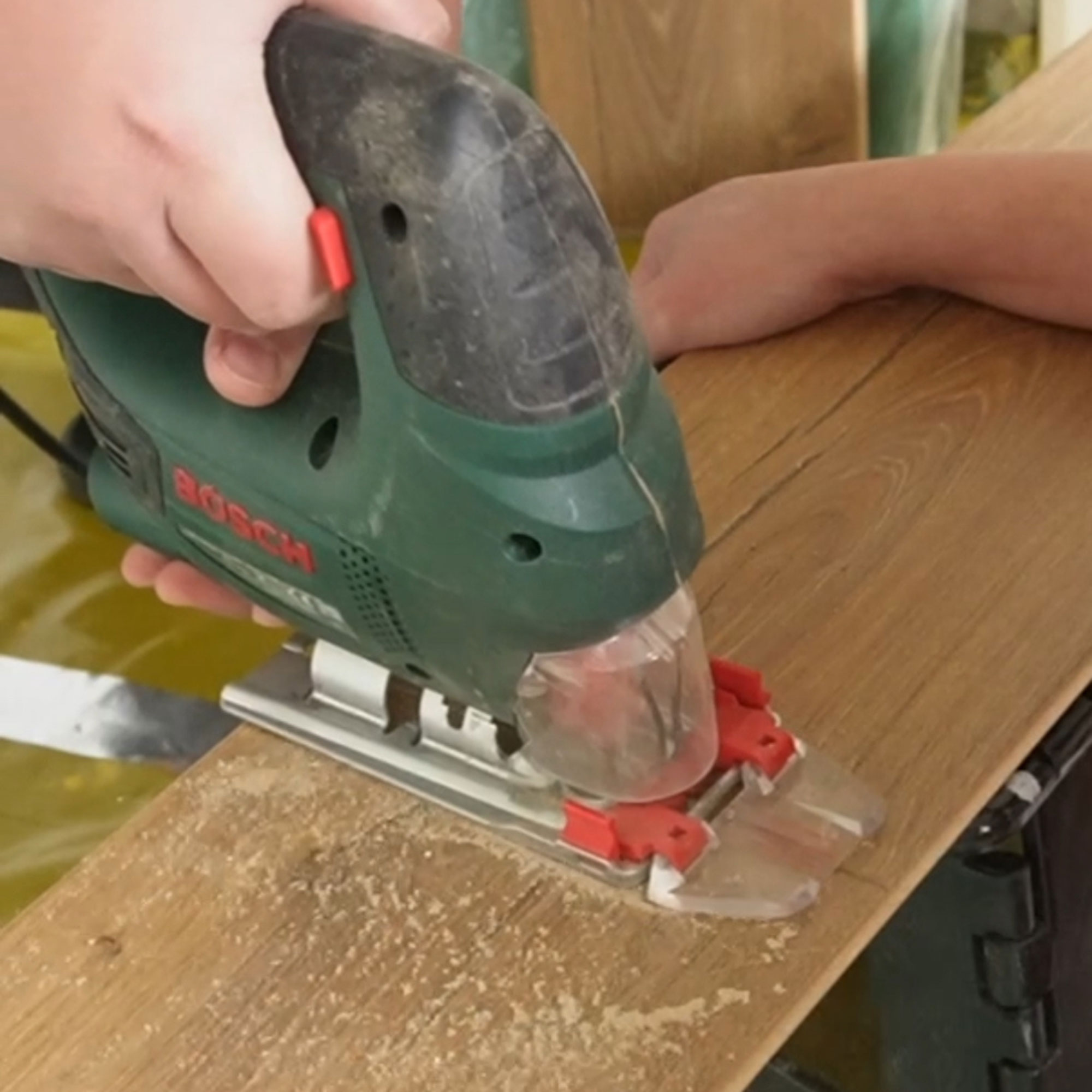 A jigsaw being used on a plank of wood
