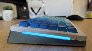 Side view of Glorious GMMK 3 keyboard showing elevation and metallic bottom case with blue RGB lighting