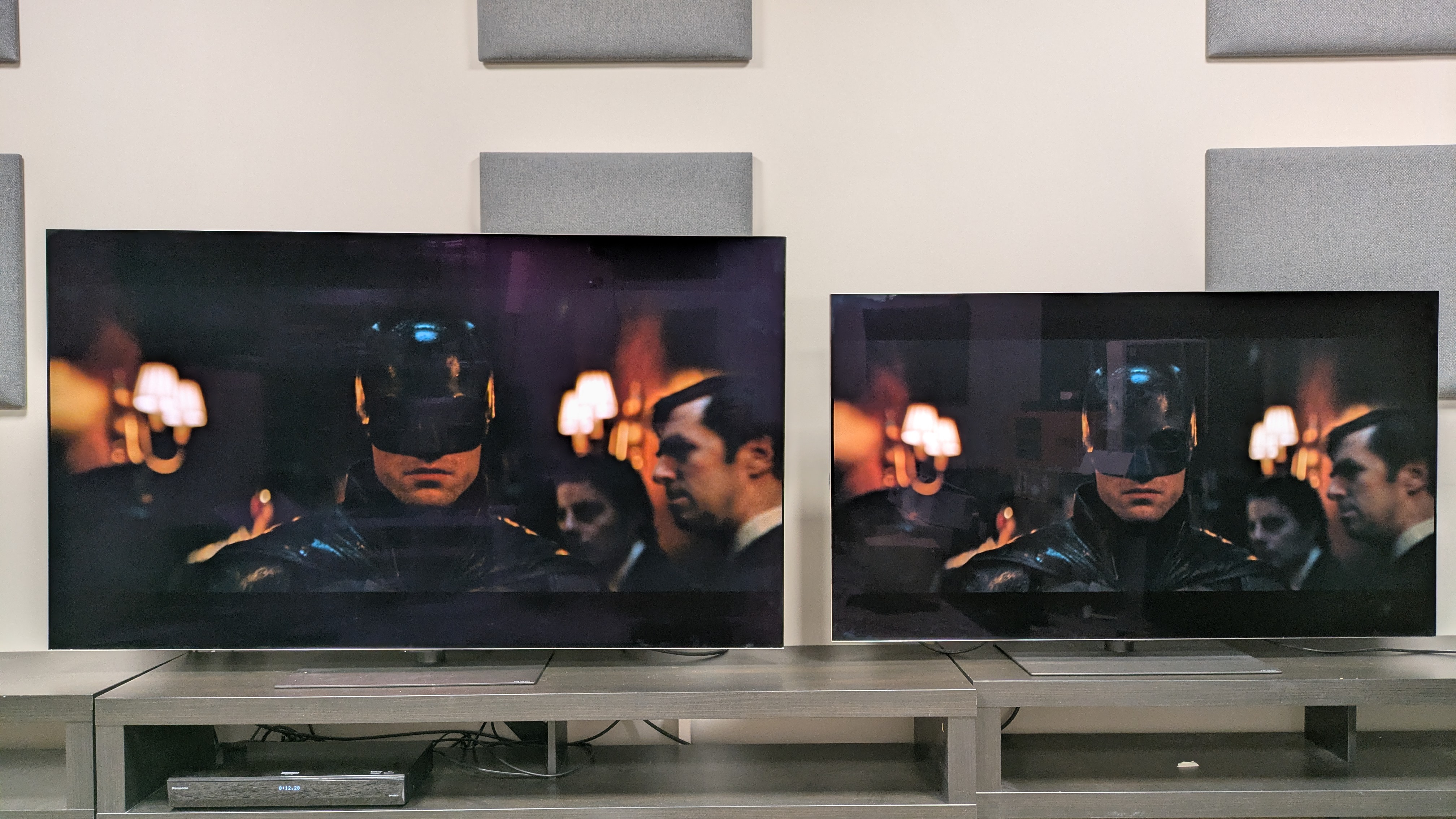 The LG G6 (left) and LG G5 (right) showing a shot of Batman's face from The Batman, in a bright room. The G5 looks brighter, but its image is also more obscured by reflections, while the G6's image looks cleaner