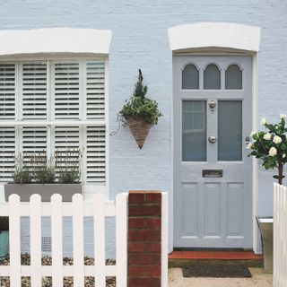 front door colour mistakes, cottage style exterior with pale grey front door, blue painted exterior walls, white accents, white picket fence