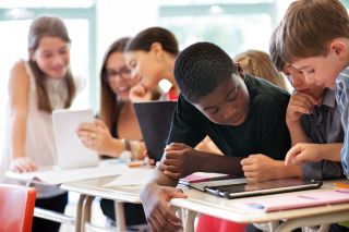 School kids in class using a digital tablet computer