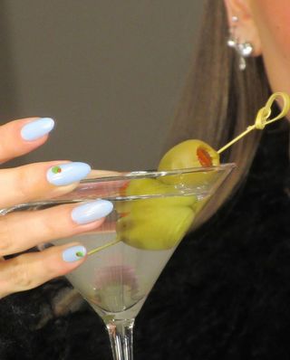 Hailey Bieber with martini cocktail olive nail art on blue base