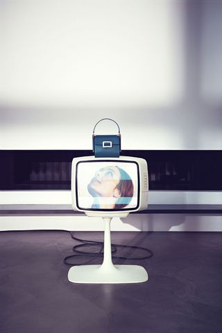 A television screen with a handbag on it