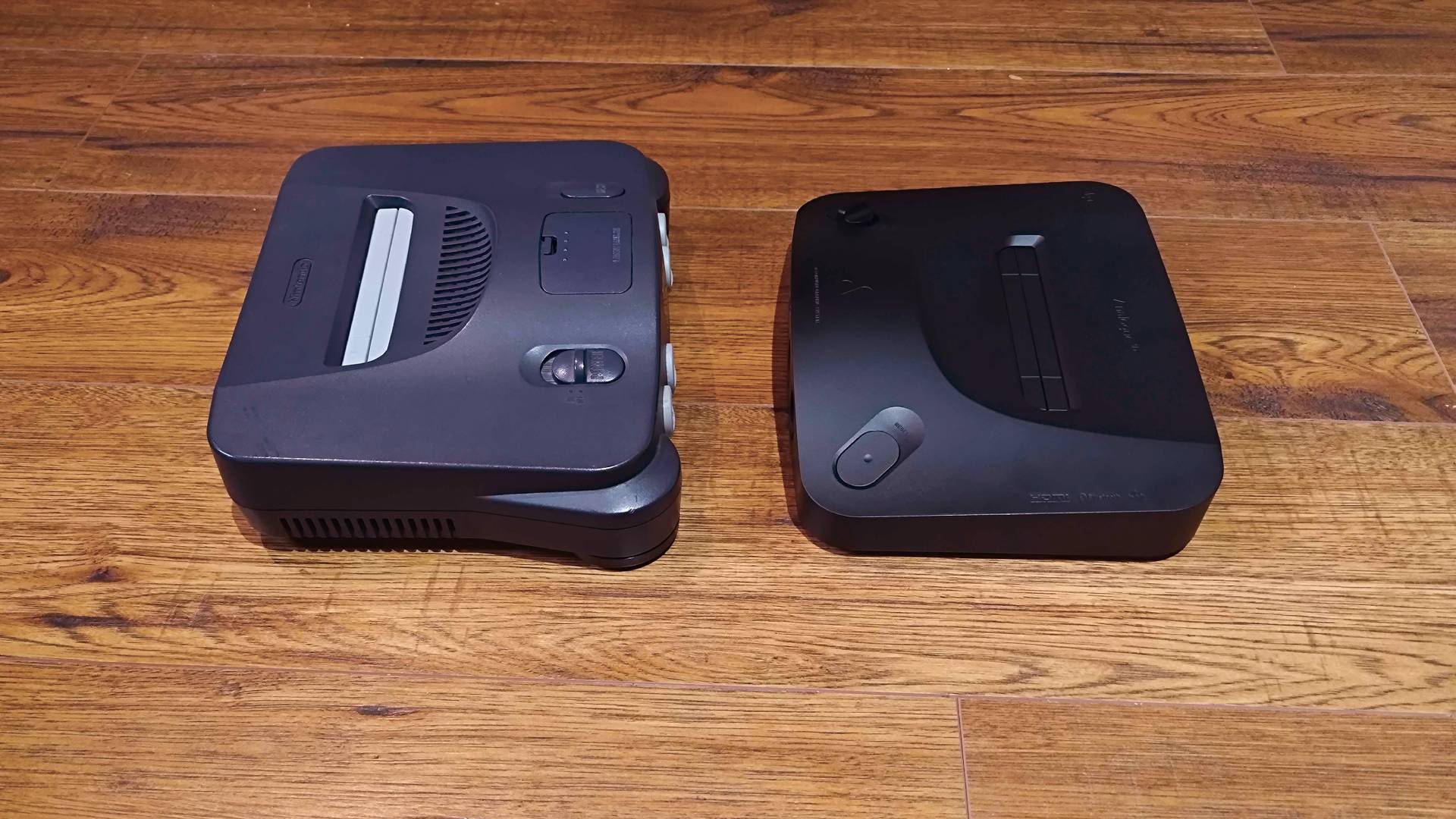 Analogue 3D on right and N64 on left facing each other on woodgrain surface.