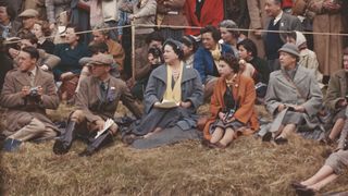 Queen Elizabeth II and the Queen Mother sitting on the ground to watch the Badminton Horse Trials, 1956. On the Queen's other side is Mary, Countess of Harewood (1897 - 1965).
