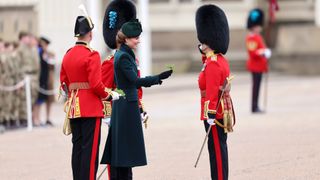 Catherine, Princess of Wales presents traditional sprigs of shamrock to a member of the Irish Guards