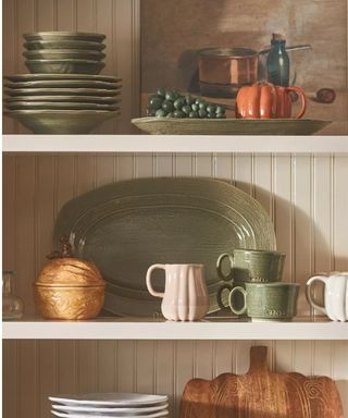 anthropologie kitchen shelves with pumpkin mugs and wooden boards