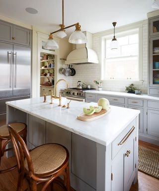 A white and grey kitchen with vintage gold hardware