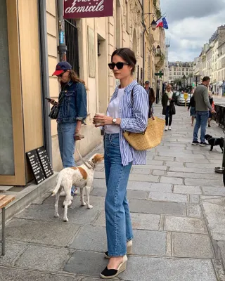 Frau in gestreiftem Hemd, Jeans und Espadrilles.