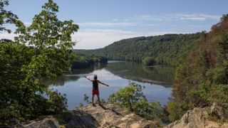 Man wearing a black tank and red shorts staring the landscape