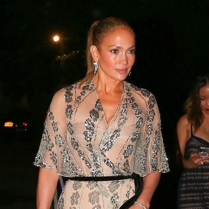 Jennifer Lopez wearing a sheer gown with black heels and a beaded purse for her 55th birthday in the Hamptons July 2024