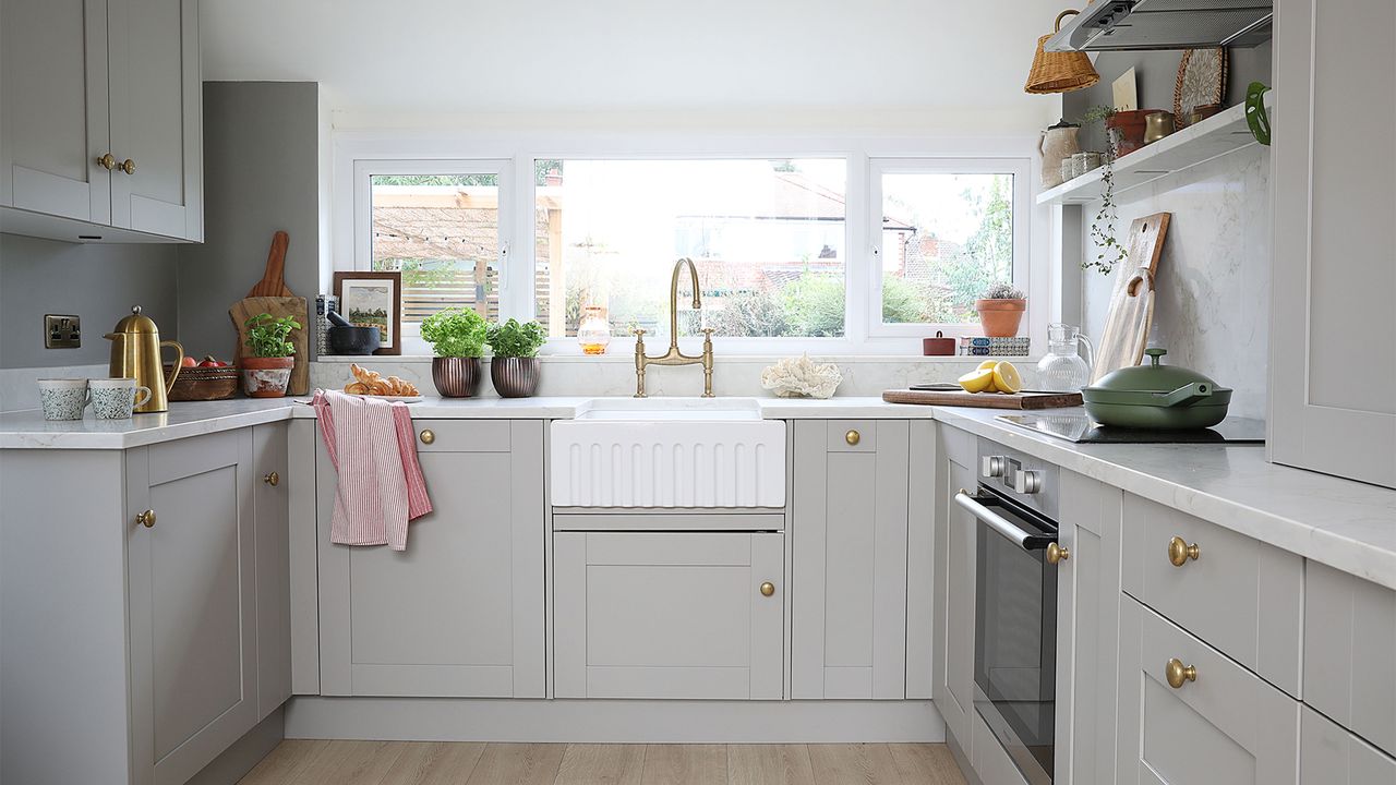 grey kitchen with white worktops and gold handles