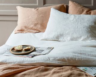 linen bed linen in nutmeg on a bed with breakfast on a tray - loaf