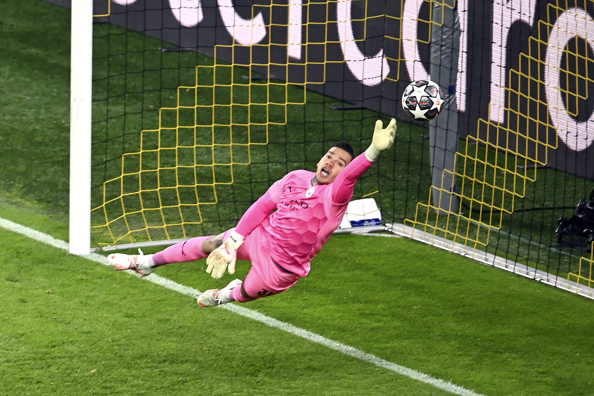 Manchester City goalkeeper Ederson dives to save a shot
