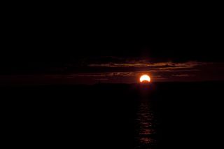 Photographer Damien Wagaman captured this view of a partial solar eclipse rising at dawn over Chesapeake Bay near Annapolis, Md., during the rare hybrid solar eclipse of Nov. 3, 2013.