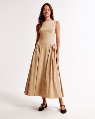 Abercrombie model wearing taupe drop waist midi dress and black ballet flats