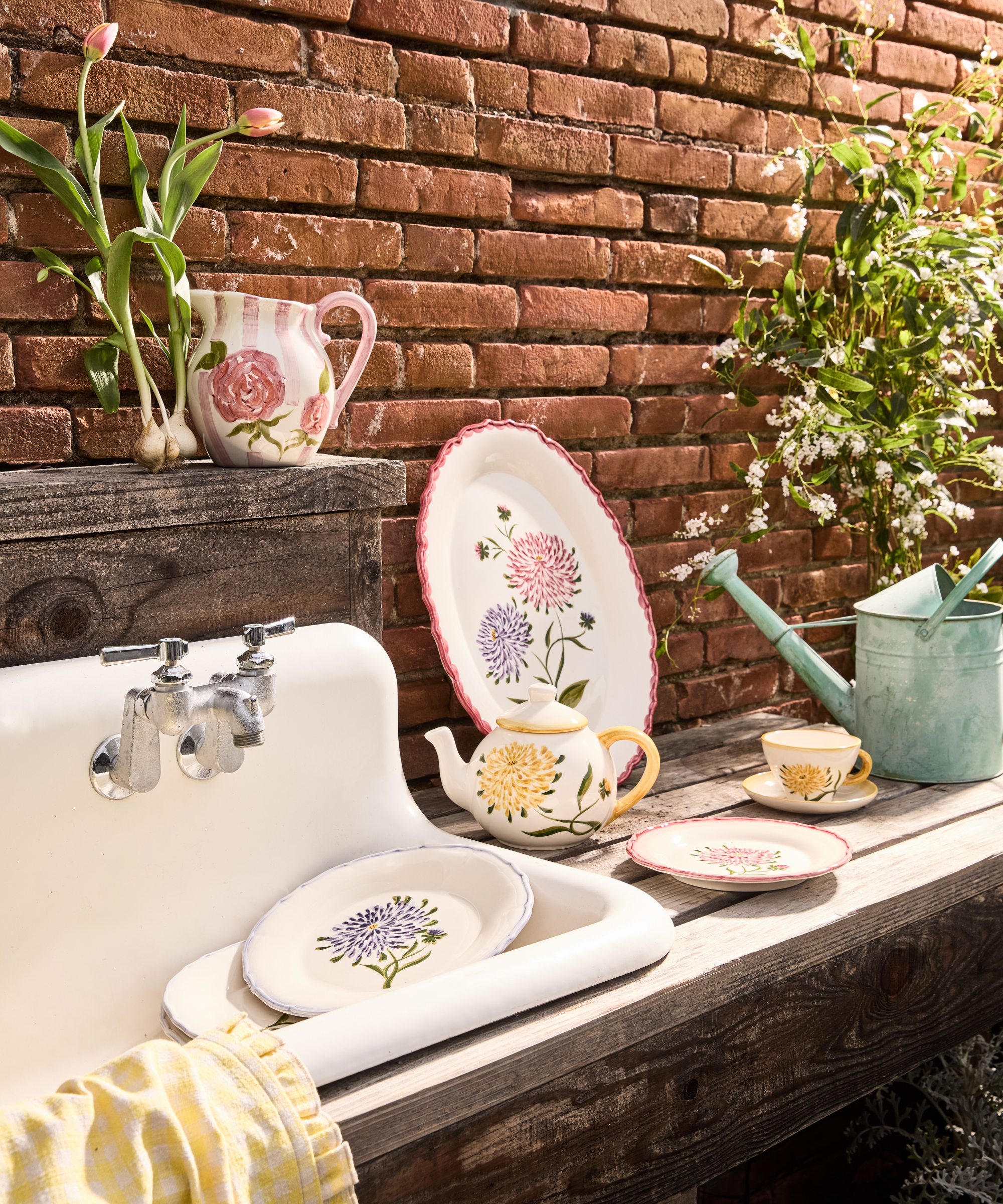 an outdoor sink with decorative tableware staged along side of it