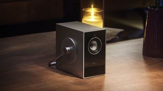 LG CineBeam Qube 4K portable projector sat on wooden table 