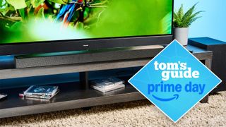 the samsung hw-b650 soundbar on a tv stand with a panasonic tv and a tom'g guide prime day badge