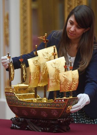 A staff member with The Vessel of Friendship before it going on display