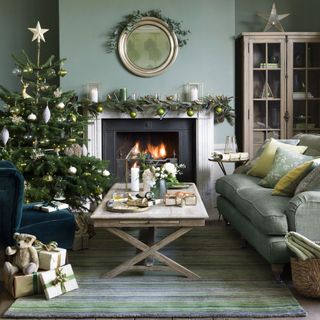 living area with christmas tree and sofa and arm chairs and fire place and round mirror