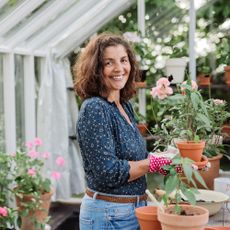 smiling woman in garden greenhouse