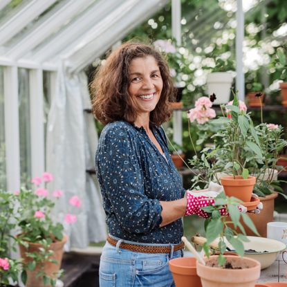 smiling woman in garden greenhouse