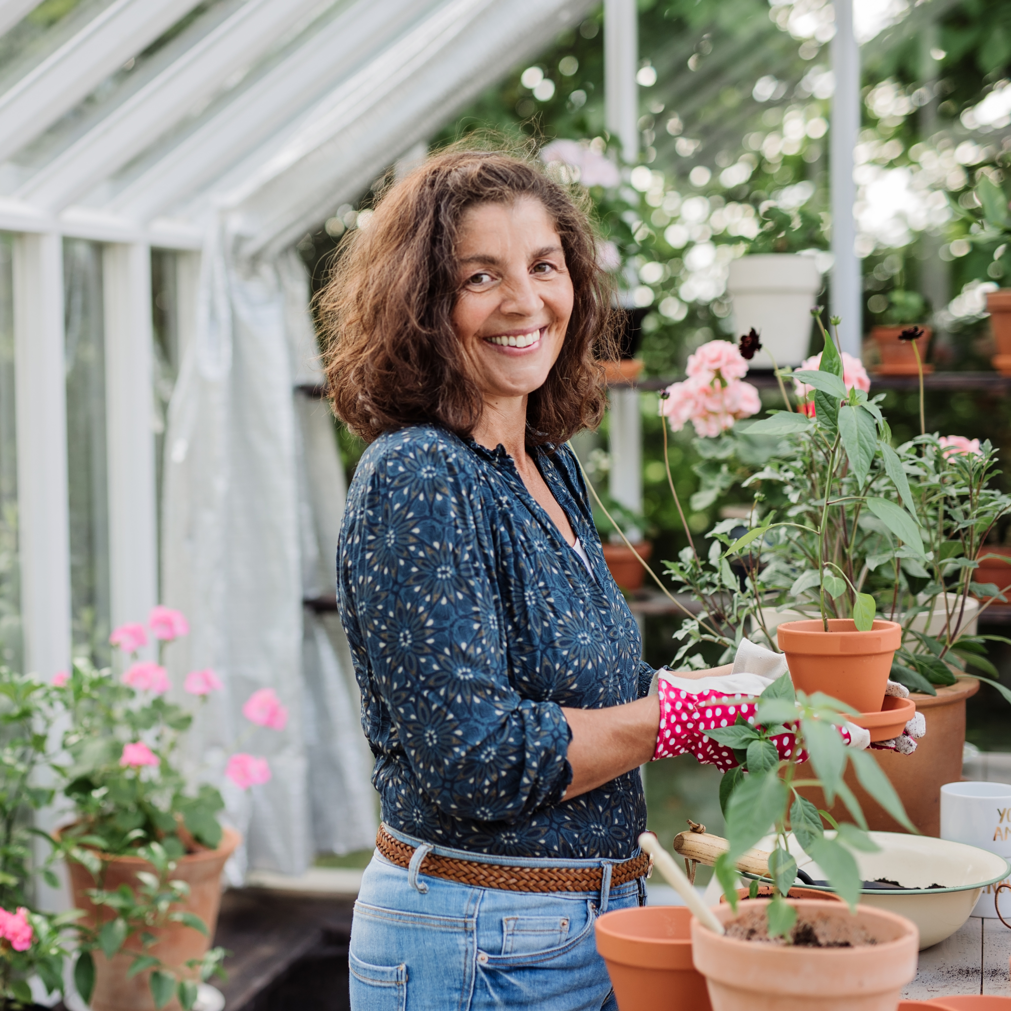 smiling woman in garden greenhouse