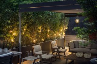 outdoor seating area underneath a pergola at night