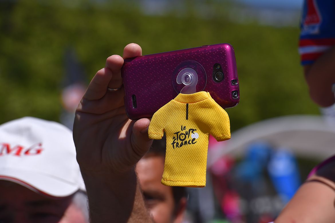 A fan gets a photo as the race passes by