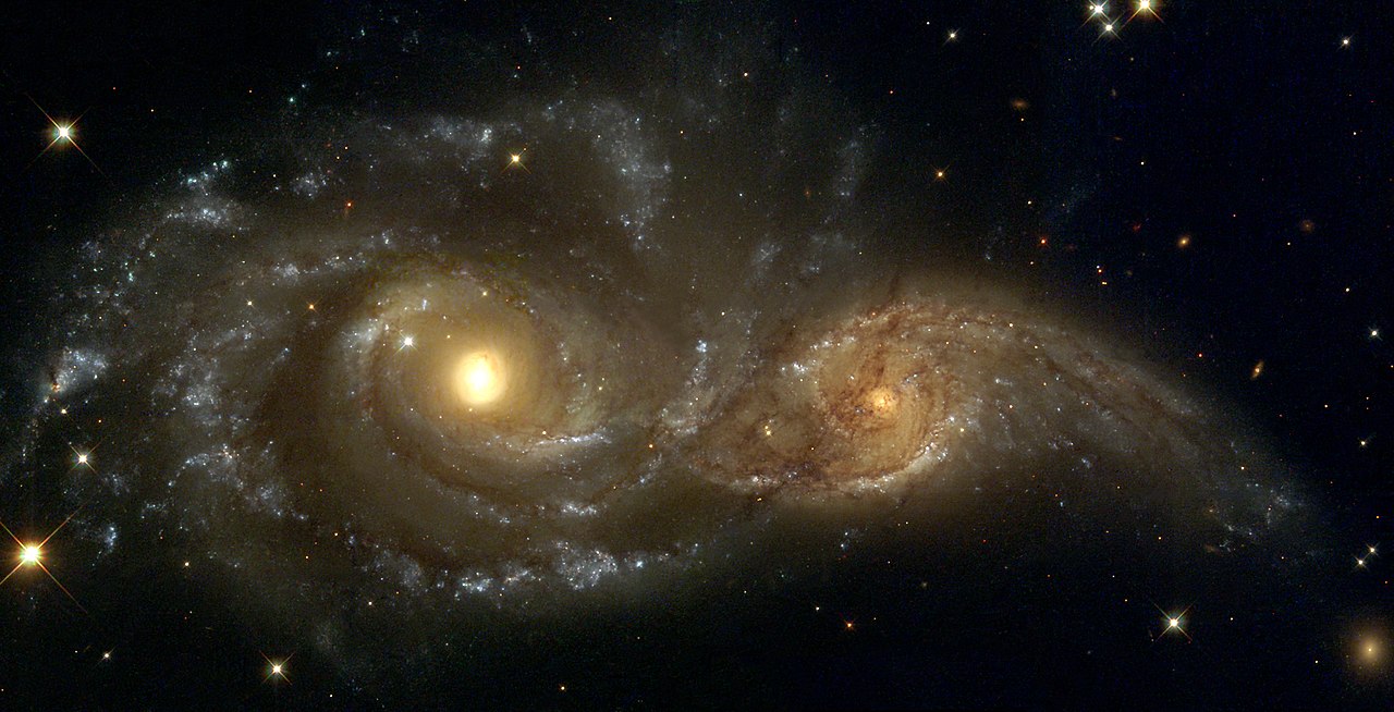 Tidal stripping occurring as the larger galaxy NGC 2207 pulls apart the smaller IC 2163 as seen by the NASA/ESA Hubble Space Telescope.