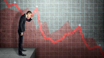 Man looking down against backdrop of negative stock chart