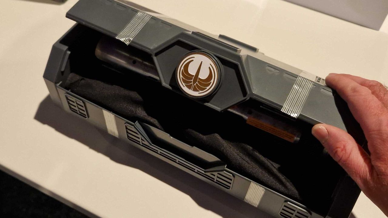 A hand opening the Master Sol Lightsaber Hilt case