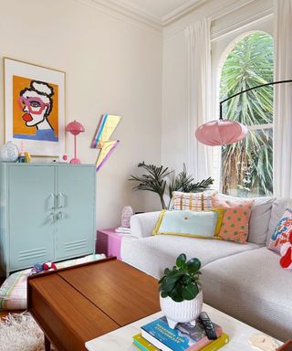 A living room with a gray couch and colorful furniture and decor