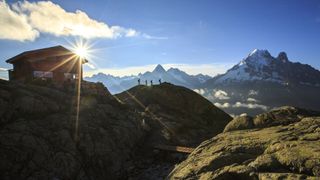 hut to hut hiking: hikers by a high mountain refuge in the French Alps