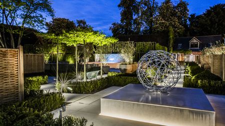 outdoor tree lighting ideas: modern urban garden with lit trees
